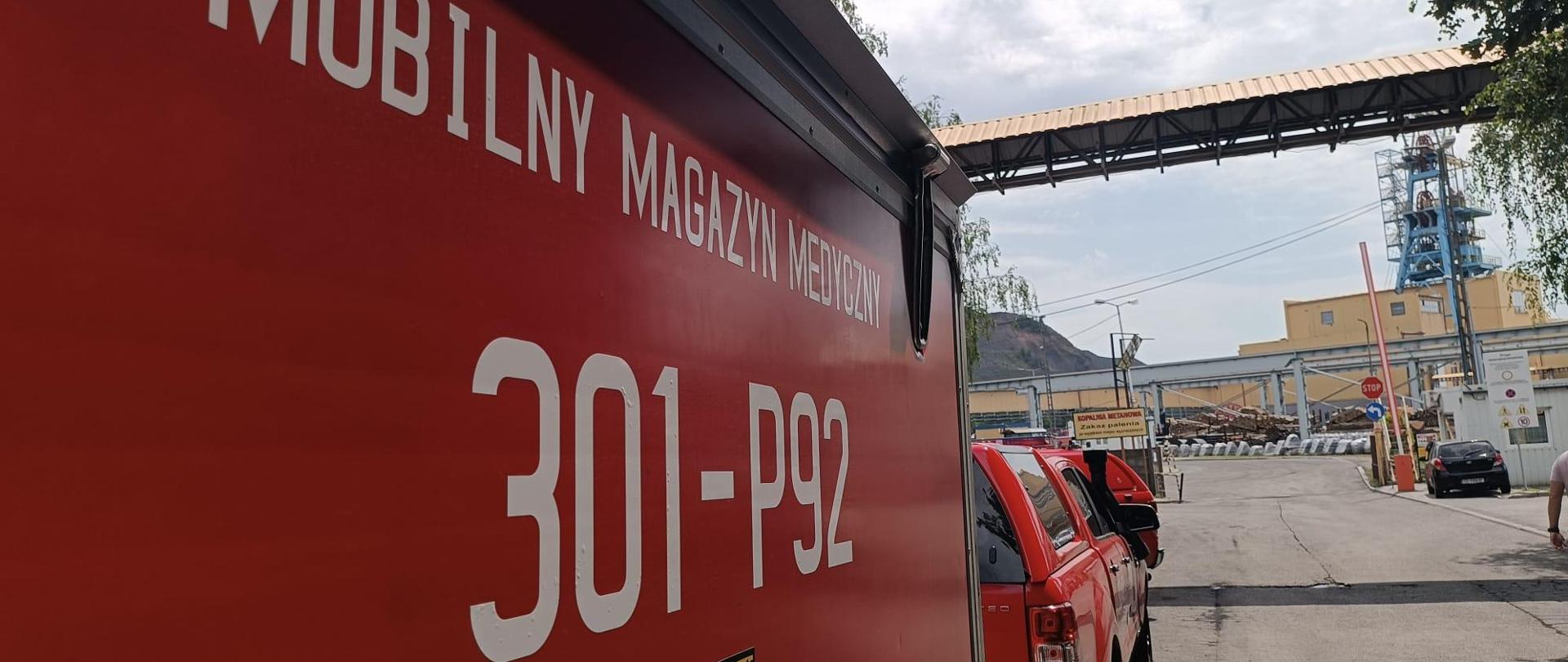bok samochodu PSP z napisem Mobilny Magazyn Medyczny, w tle budynek kopalni