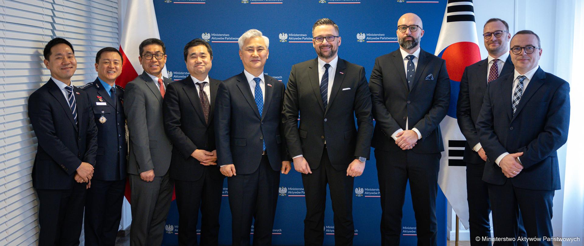 Family photo. Przedstawiciele strony polskiej i koreańskiej na tle ścianki z logotypami MAP. 