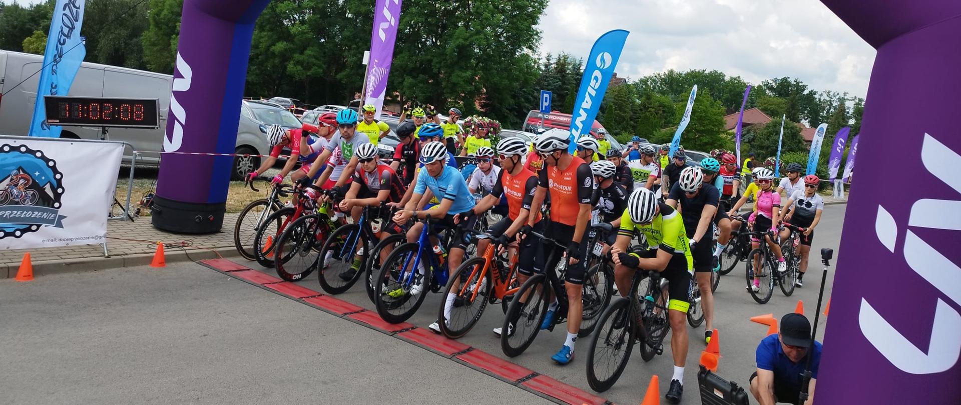 Na mecie startu rusza grupa kolarzy