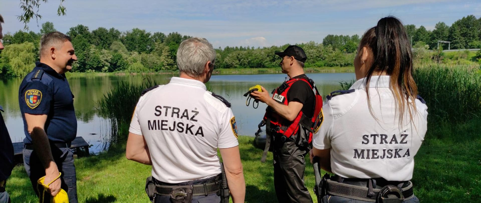 
Zdjęcie przedstawia strażaków szkolących strażników miejskich.