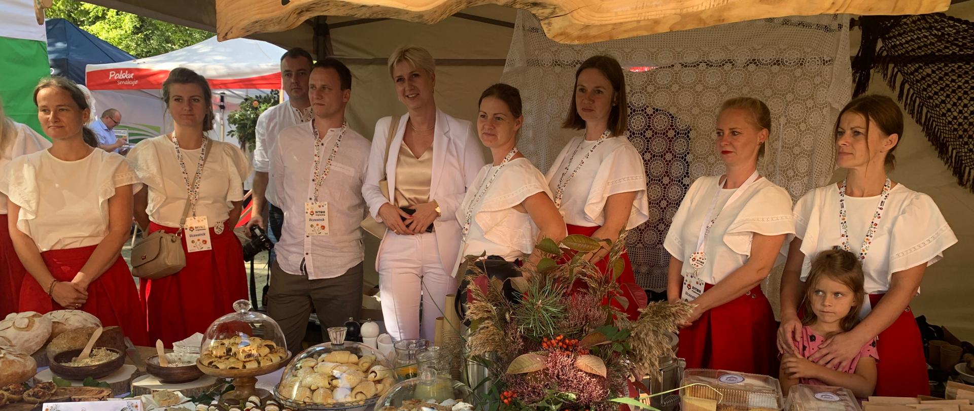 Na tle stoiska KGW Zagacie stoi 7 kobiet oraz 2 mężczyzn i 1 dziecko