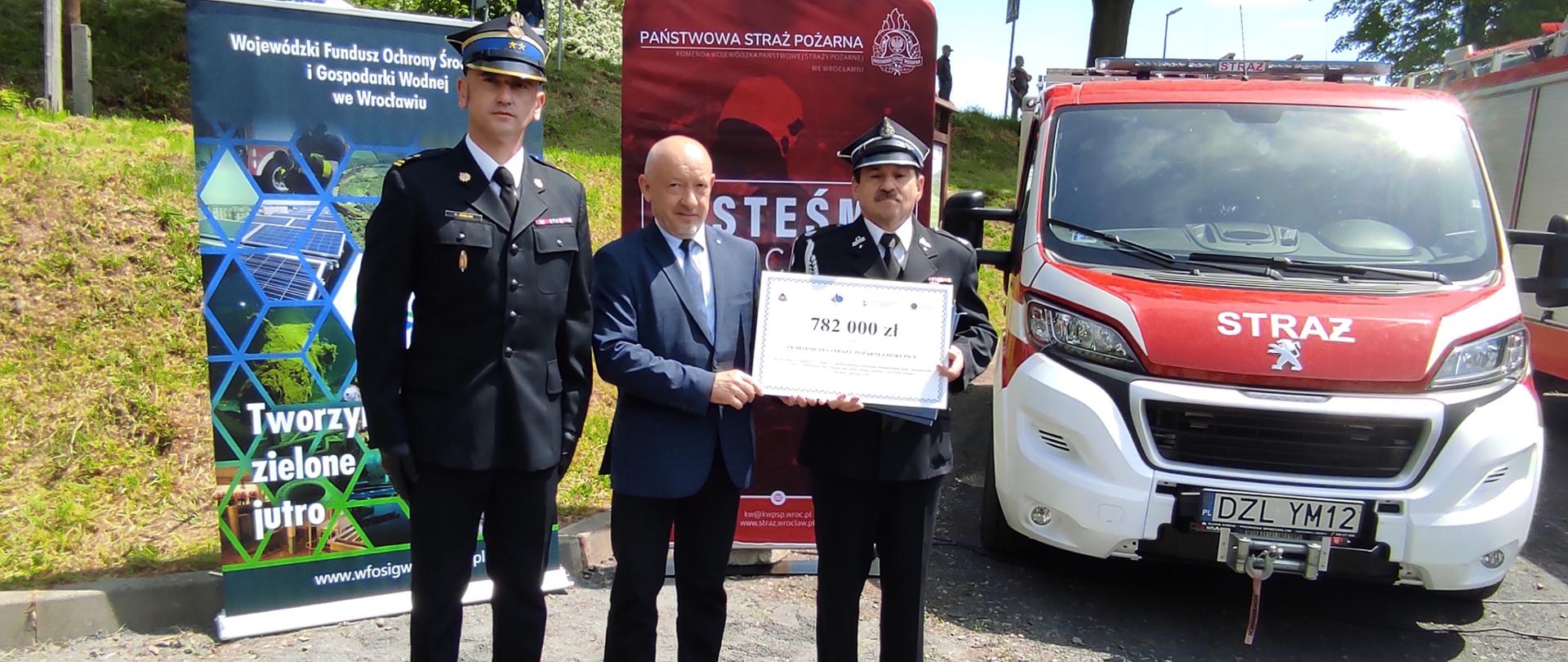 na zdjęciu widać, od prawej: Marek Starczewski OSP Biskupice, Romuald Piórko Gmina Jelcz-Laskowice, Krzysztof Gielsa KP PSP Oława. Panowie trzymają symboliczny czek na 782.000zł na zakup samochodu dla OSP w Biskupicach
