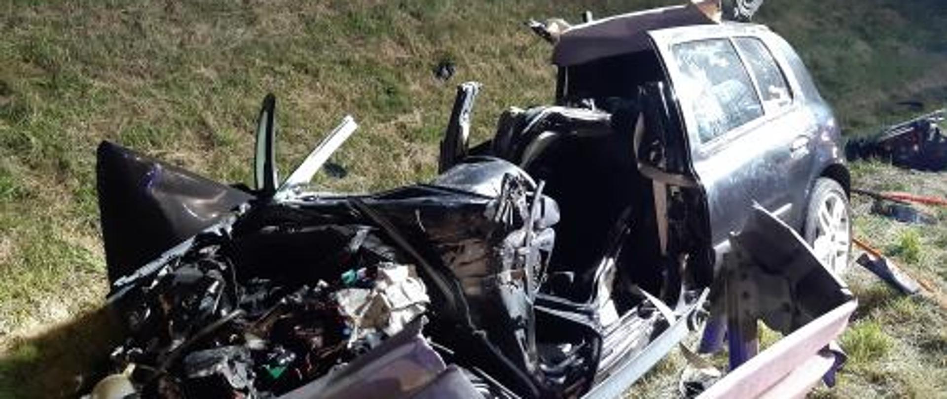 samochód osobowy po wypadku. Widać ogromne zniszczenia karoserii. Dach pojazdu usunięty przez Straż Pożarną.