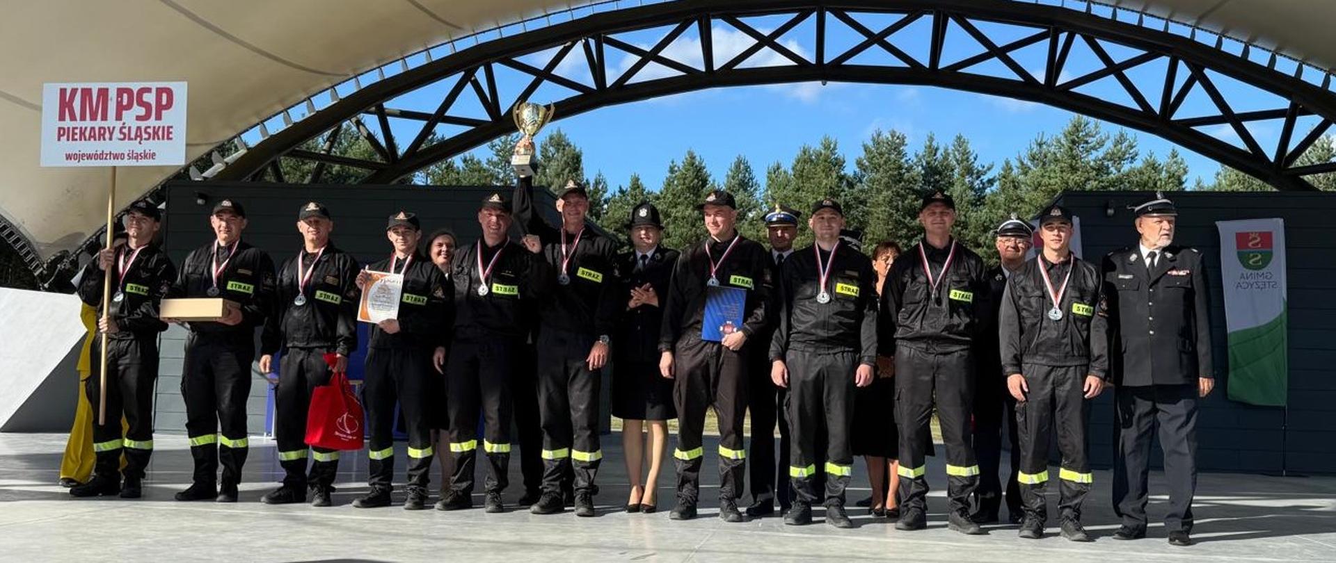 Zdjęcie przedstawia strażaków z Komendy Miejskiej Państwowej Straży Pożarnej w Piekarach Śląskich podczas ceremonii zakończenia Zawodów Sportowo-Pożarniczych wg międzynarodowego regulaminu CTIF