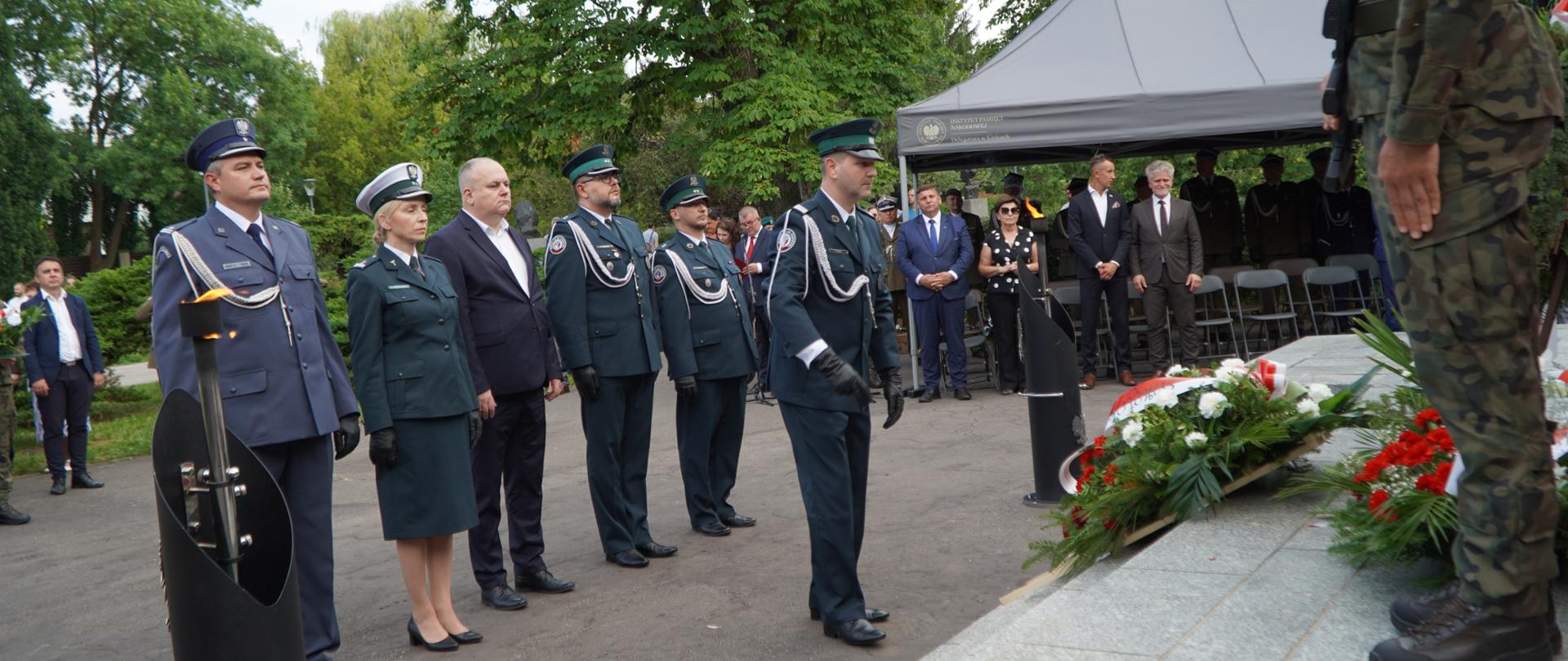 Delegacja mundurowych składa kwiaty przed pomnikiem