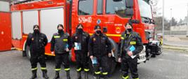Zdjęcie przedstawia strażaków biorących udział w akcji dystrybucji ulotek dot. szczepień.