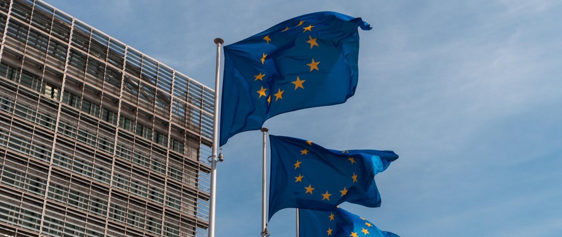Flagi UE na tle wieżowca
