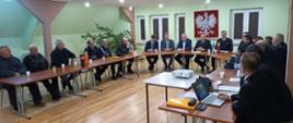 Zebrania sprawozdawcze OSP w powiecie grajewskim goście siedzą przy stole konferencyjnym.