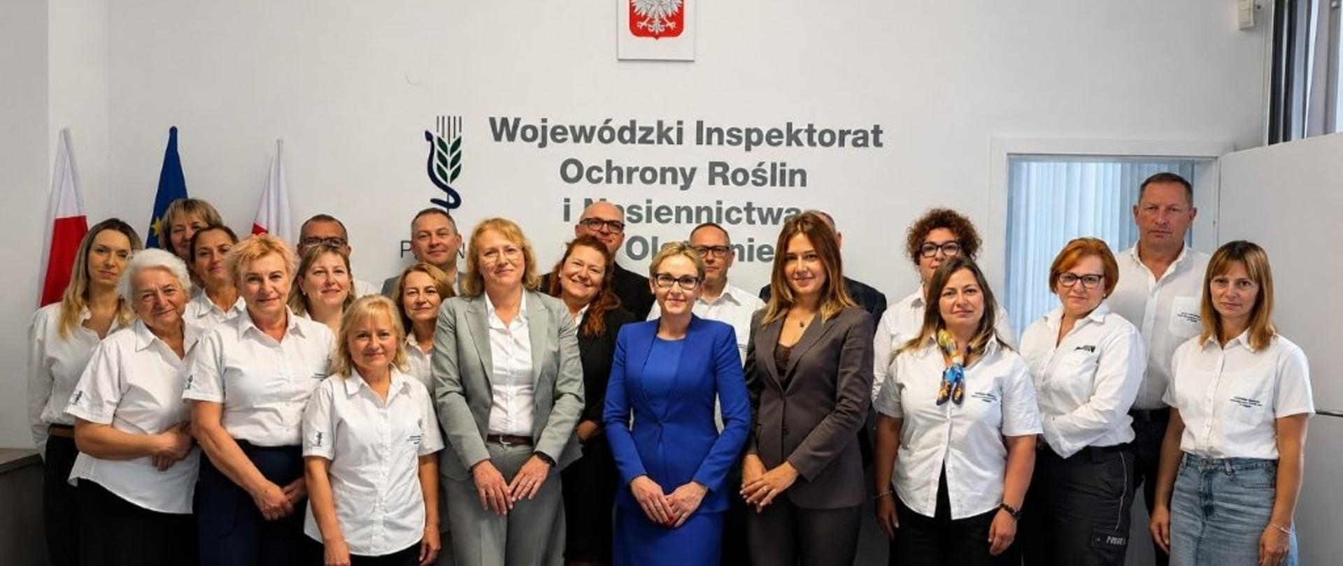 grupa osób stoi pozując do zdjęcia, większość ma białe koszule