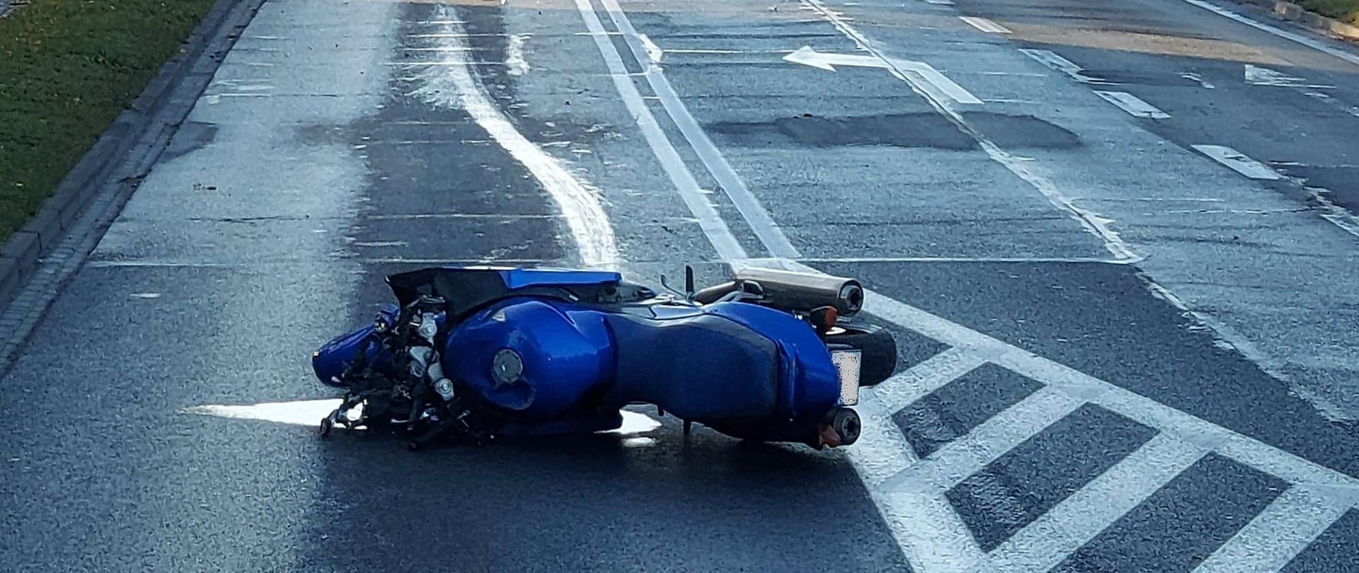Zderzenie samochodu osobowego z motocyklem. Motocykl leży na jezdni. 