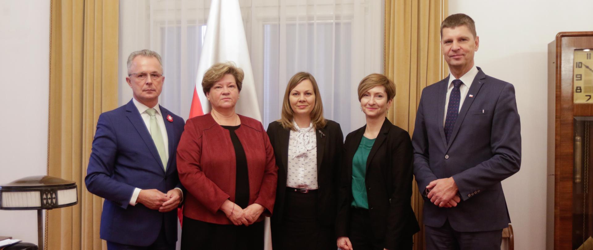 Przedstawiciele Ministerstwa Edukacji i Nauki oraz Ośrodka Rozwoju Polskiej Edukacji za Granicą pozują w szeregu do zdjęcia w pokoju.