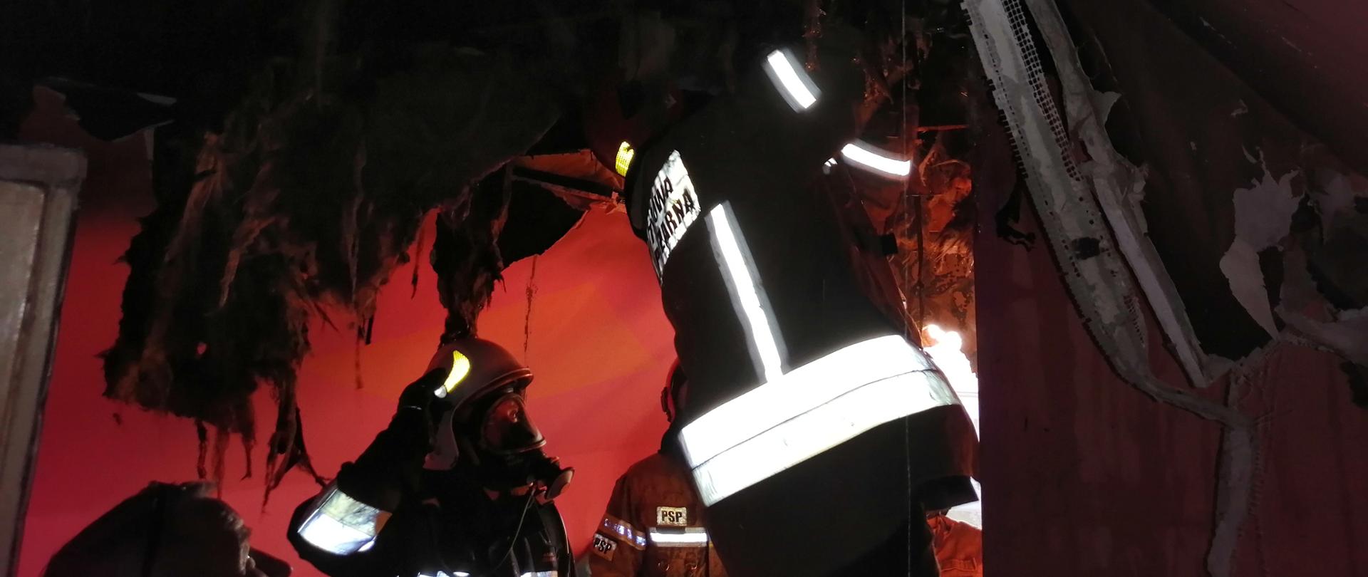 Na zdjęciu strażacy dokonują niezbędnych prac rozbiórkowych elementów poddasza