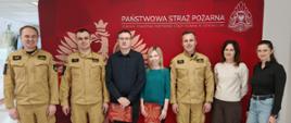 Zdjecie Przedstawia Mł. bryg. Marcina Jasińskiego Komendanta Powiatowego PSP w Ostrowcu Świetokrzyskim wraz z jego Zastępcą bryg. Tomaszem Łyjakiem oraz innymi pracownikami w Komendzie Powiatowej PSP w Ostrowcu Św. po wręczeniu podziekowań z okazji dnia służby cywilnej.