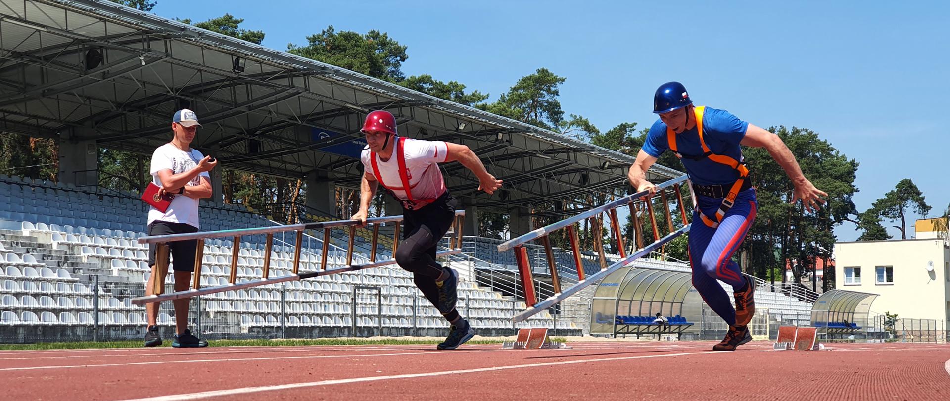 Strażacy ćwiczą wspinanie przy pomocy drabiny hakowej