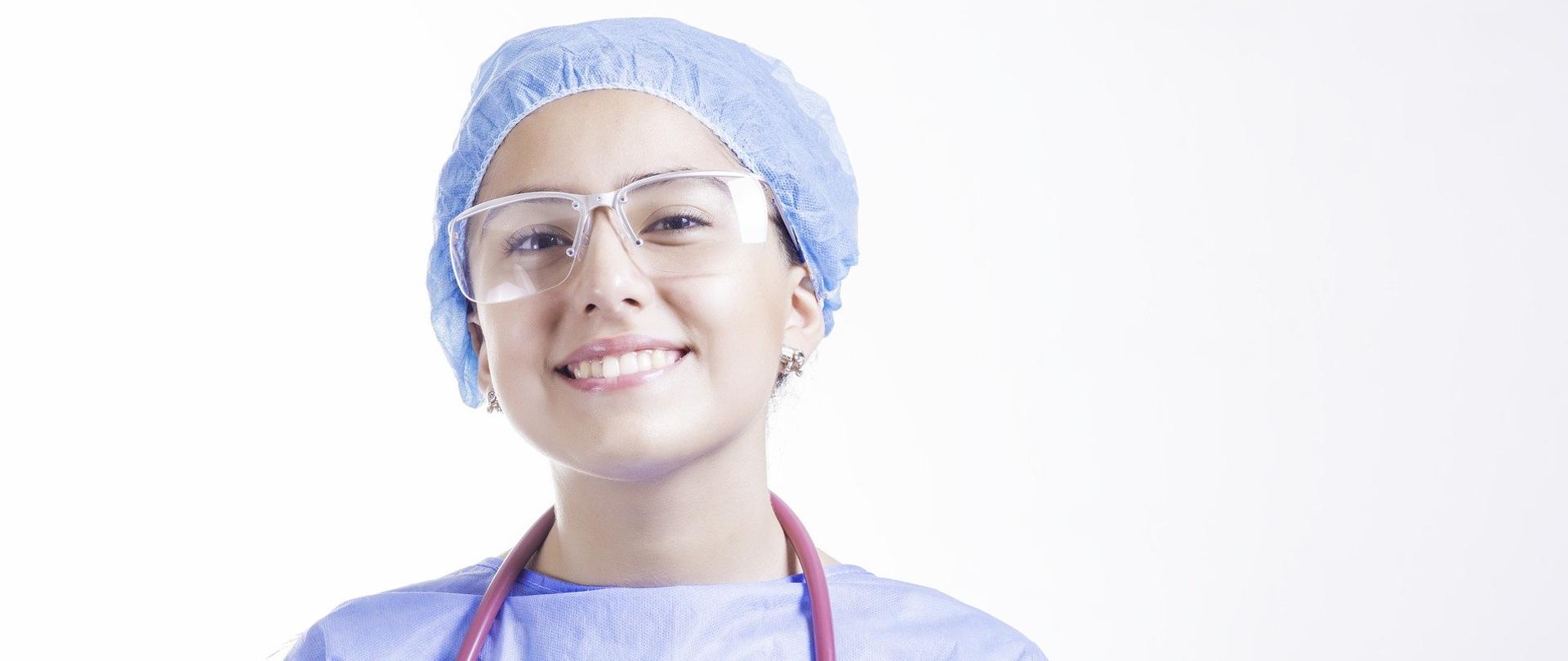 Uśmiechnięta pielęgniarka w fartuchu.