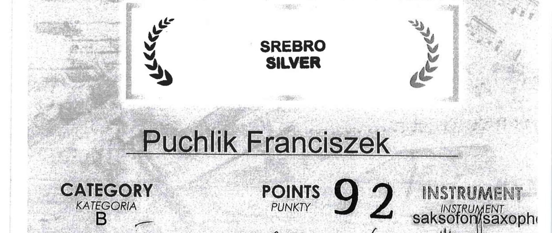 
białe tło, czarny tekst, logo Fundacji Pro Musica VI Międzynarodowy Konkurs Instrumentów Dętych, 13-16 listopada 2024, srebro, Franciszek Puchlik, kategoria B, saksofon
