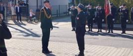 Zastępca Małopolskiego Komendanta Wojewódzkiego PSP odbiera meldunek od dowódcy uroczystości.