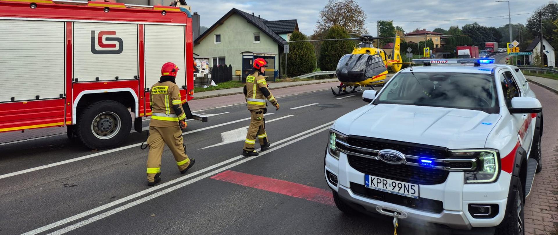 Wypadek drogowy - auta strażackie i helikopter ratowniczy stoją na jezdni