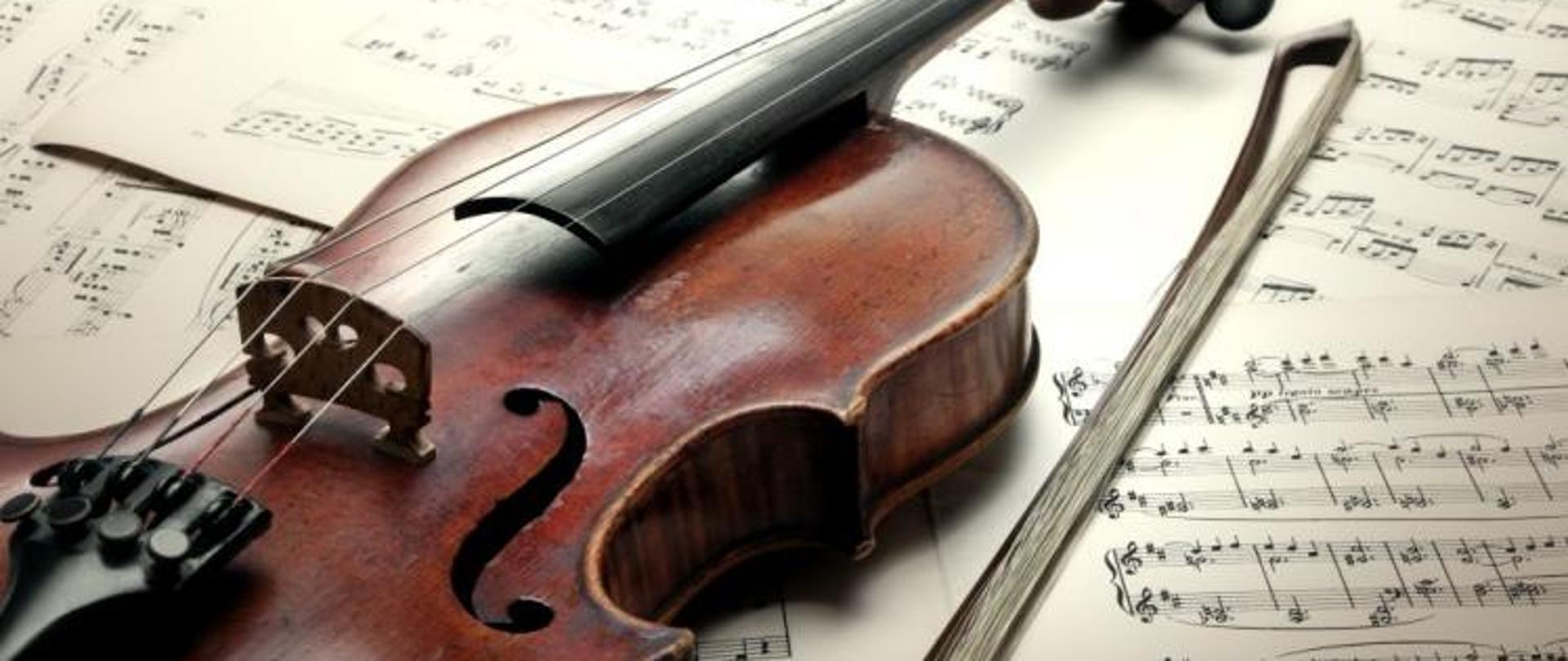 Zdjęcie przedstawiające skrzypce ze smyczkiem i partyturą