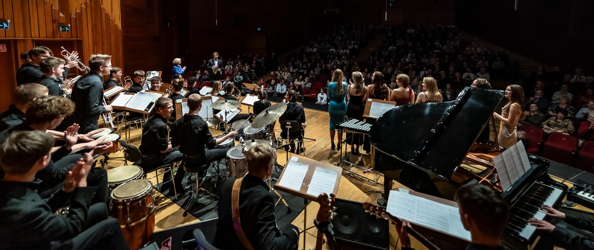 zdjęcie big bandu szkolnego podczas koncertu mikołajkowego, w tle publiczność 