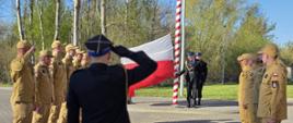 Dwie zmiany służbowe strażaków przygotowujące się do uroczystości wciągnięcia flagi na maszt.
