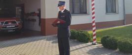 Narodowe Święto Niepodległości. Plac przed Komendą Powiatową PSP w Rawiczu. Zbiórka strażaków zmiany służbowej nr 3 JRG. Zastępca dowódcy JRG odczytuje życzenia przesłane przez przełożonych.