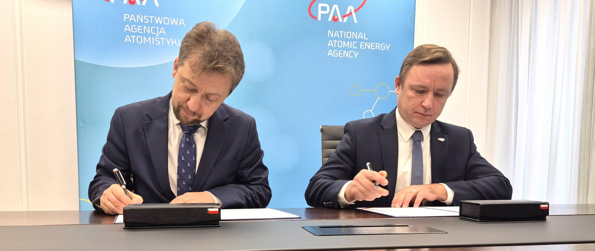 Na zdjęciu widoczny jest Andrzej Głowacki, Prezes Państwowej Agencji Atomistyki oraz Piotr Otawski, Generalny Dyrektor Ochrony Środowiska podczas podpisywania porozumienia.