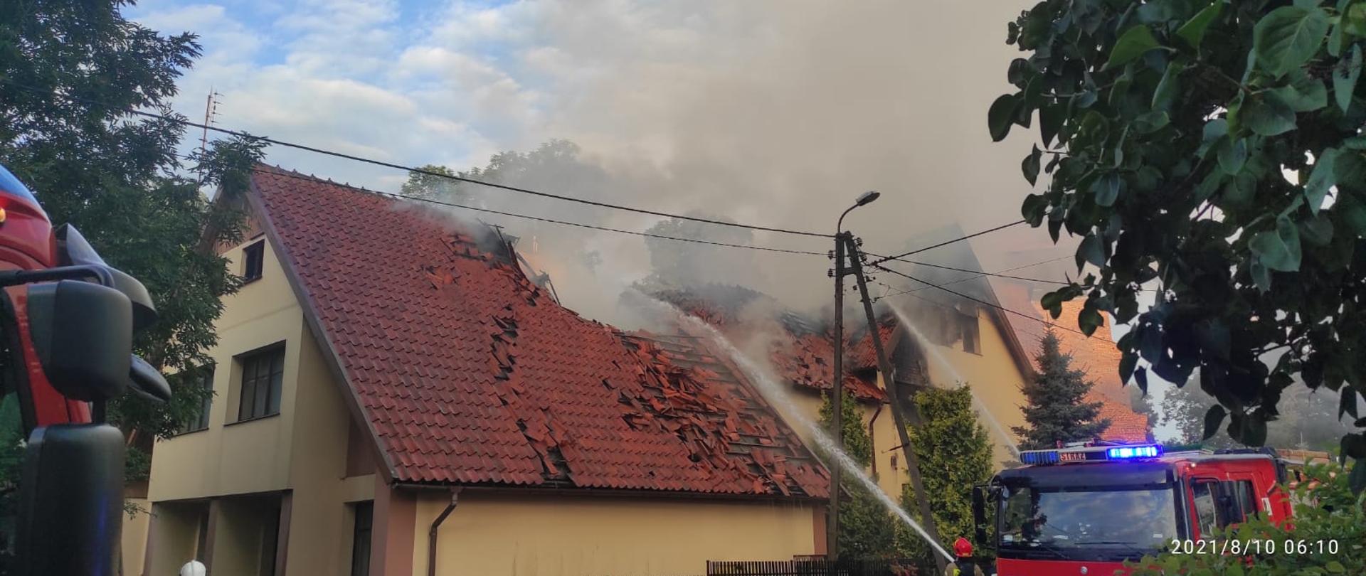 
Fotografia przedstawia pożar budynku plebanii w Nowy Stawie. Na miejscu zdarzenia widać strażaków prowadzących akcję gaśniczą.
