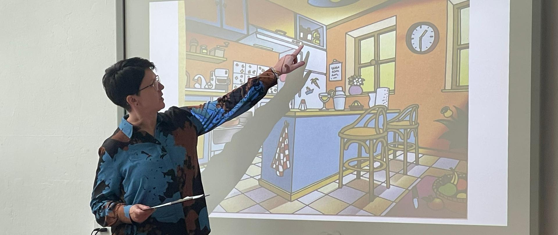 Prowadząca warsztaty tłumaczy zasady zadania