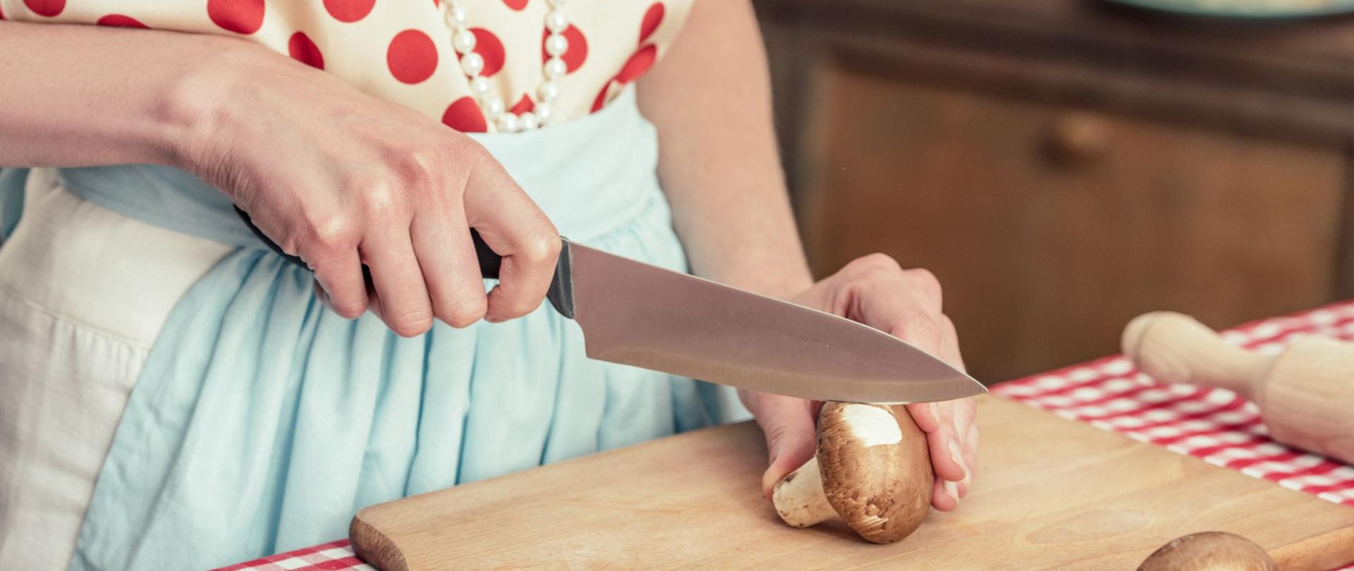 Na zdjęciu jest kobieta, która kroi grzyby. Znajduje się w kuchni.