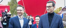 Premier Morawiecki i minister Buda stoją wśród kamer 