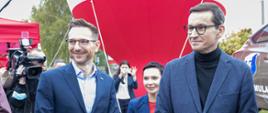 Premier Morawiecki i minister Buda stoją wśród kamer 