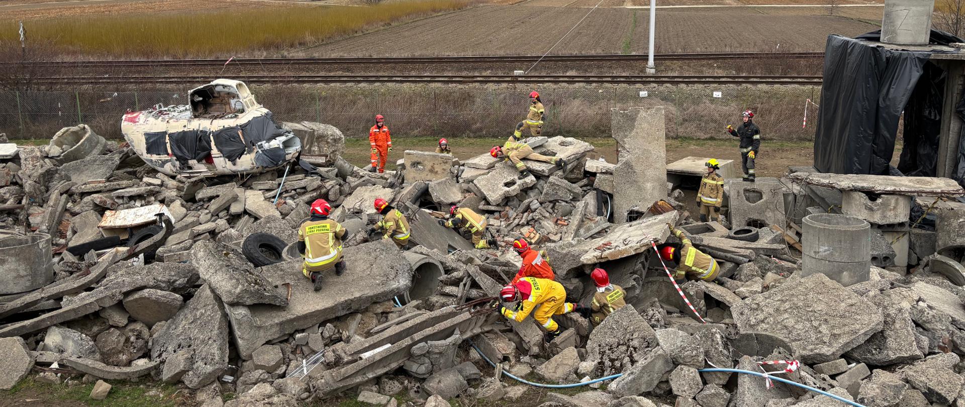 ratownicy prowadzący poszukiwania w strukturze gruzowiska