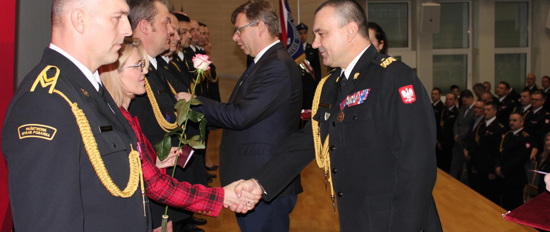 Wojewoda wręczający medal strażakowi