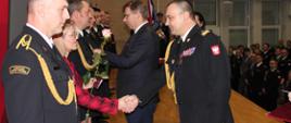 Wojewoda wręczający medal strażakowi