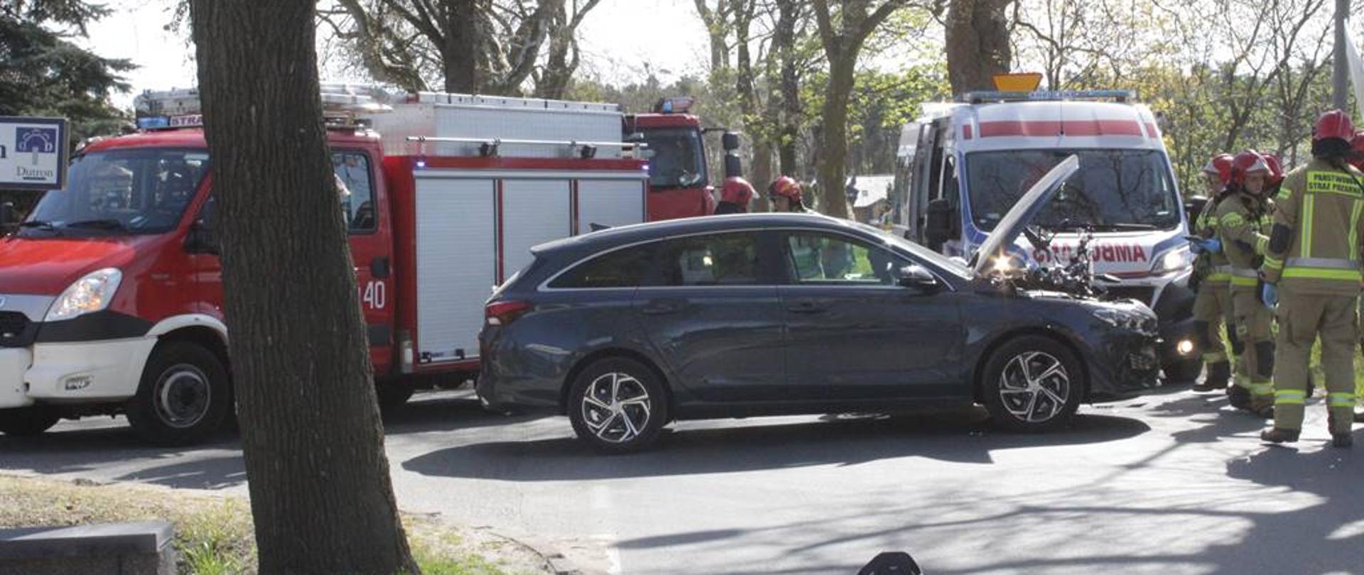 Na zdjęciu samochód osobowy z otwartą maską pojazd straży pożarnej oraz ZRM i strażacy 
