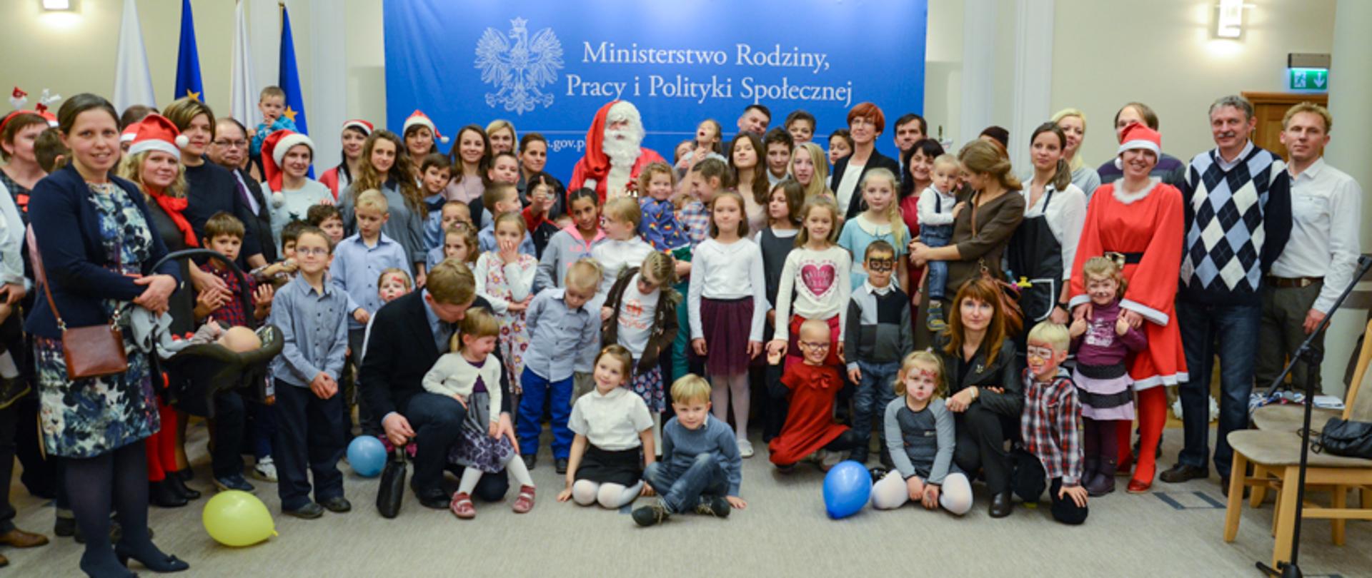 Rodzinne spotkanie mikołajkowe. Wspólne zdjęcie minister Elżbiety Rafalskiej z uczestnikami rodzinnego spotkania mikołajkowego w Ministerstwie Rodziny, Pracy i Polityki Społecznej