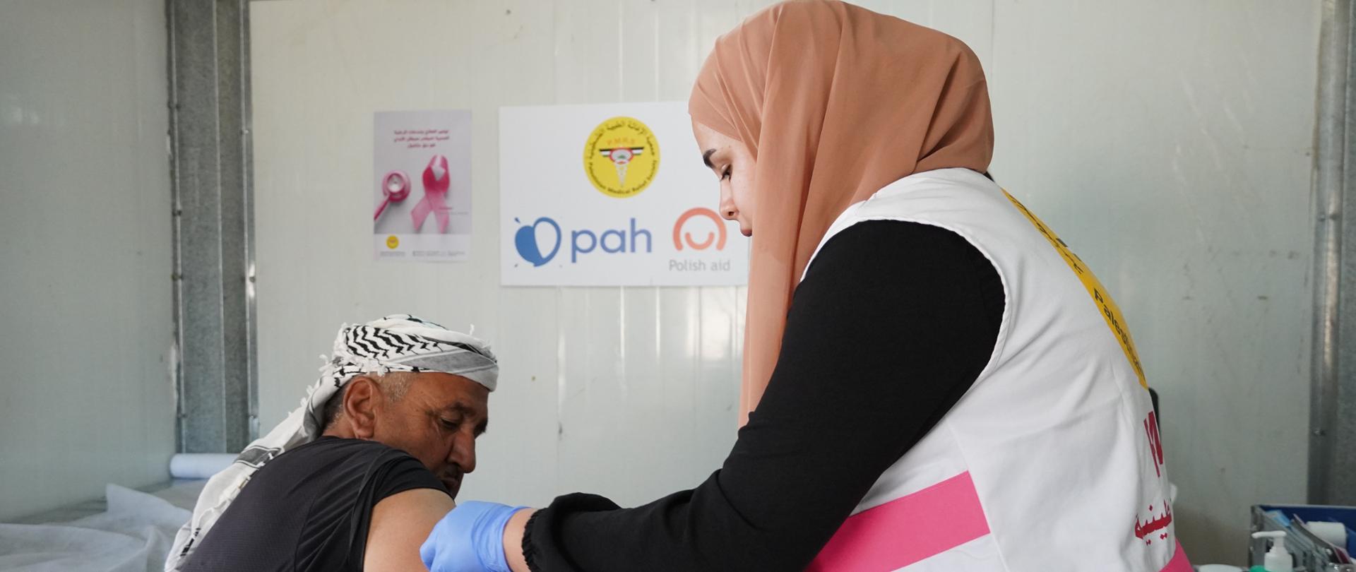 Lekarka robi badanie ciśnienia krwi starszemu mężczyźnie. 