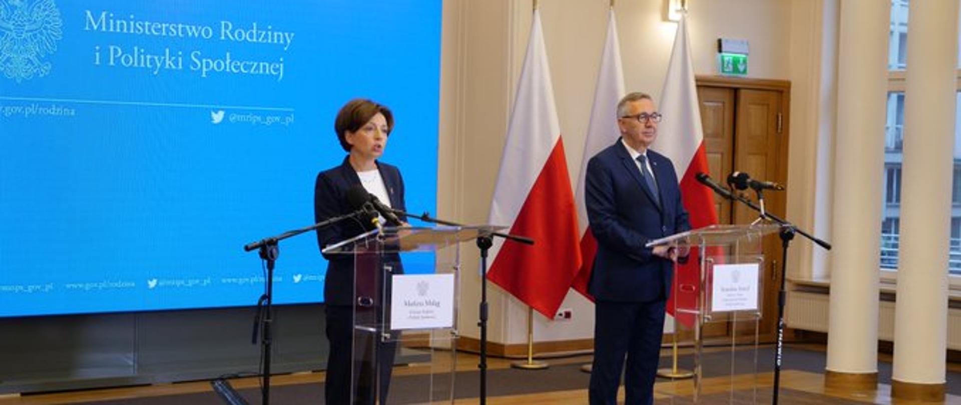Sala w Ministerstwie Rodziny i Polityki Społecznej. Przy mównicach minister Marlena Maląg oraz wiceminister Stanisław Szwed. W tle baner z logiem ministerstwa.