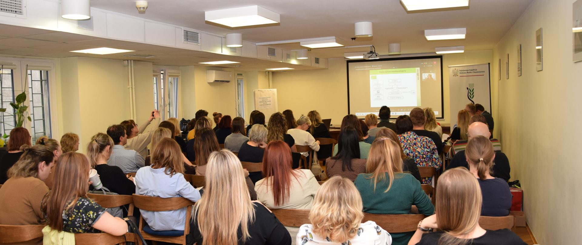 Uczestnicy szkolenia siedzą na sali konferencyjnej.