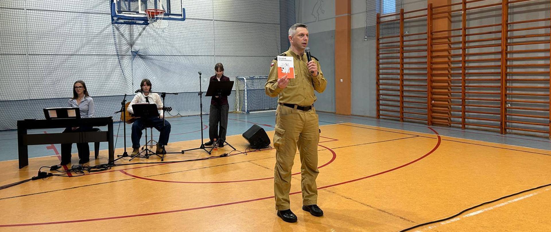 Strażak prezentuje poradnik bezpieczeństwa 