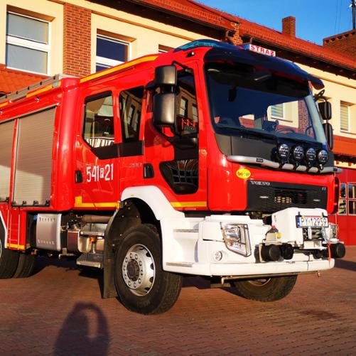 Na zdjęciu średni samochód gaśniczy marki VOLVO przed budynkiem Jednostki Ratowniczo-Gaśniczej