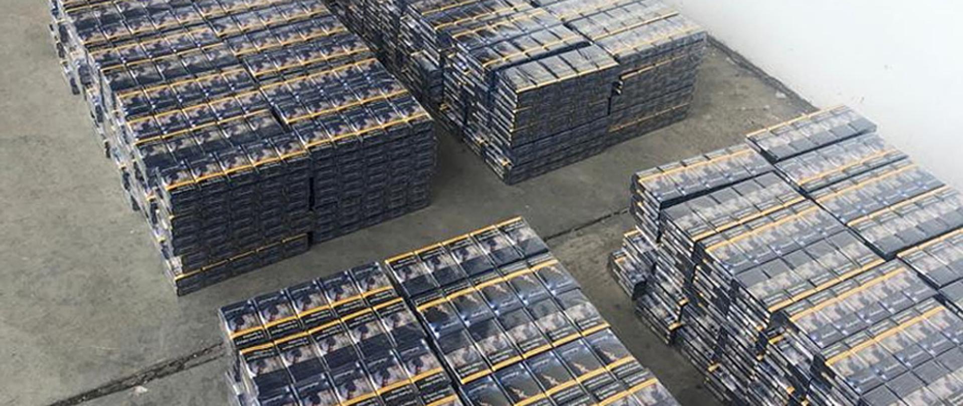 Paczki papierosów ułożone na ziemi.