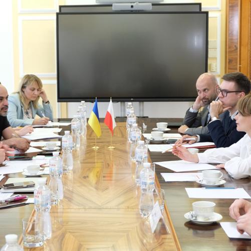 Rozmowy polskiej i ukraińskiej delegacji w Kijowie. Po obu stronach długiego drewnianego stołu siedzą przedstawiciele obu państw.