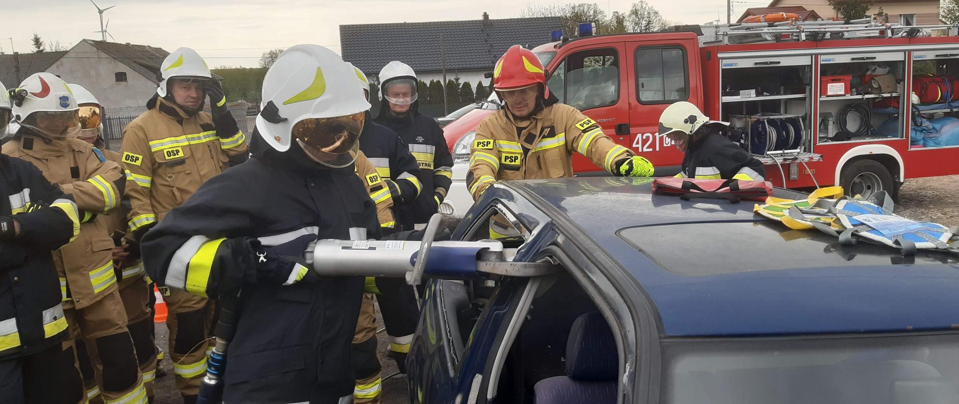 Na zdjęciu znajdują się strażacy OSP podczas zajęć z ratownictwa technicznego podczas kursu podstawowego dla strażaków ratowników OSP. Zdjęcie wykonano na terenie Centrum Motoryzacyjnego w Trzebiełuchu.