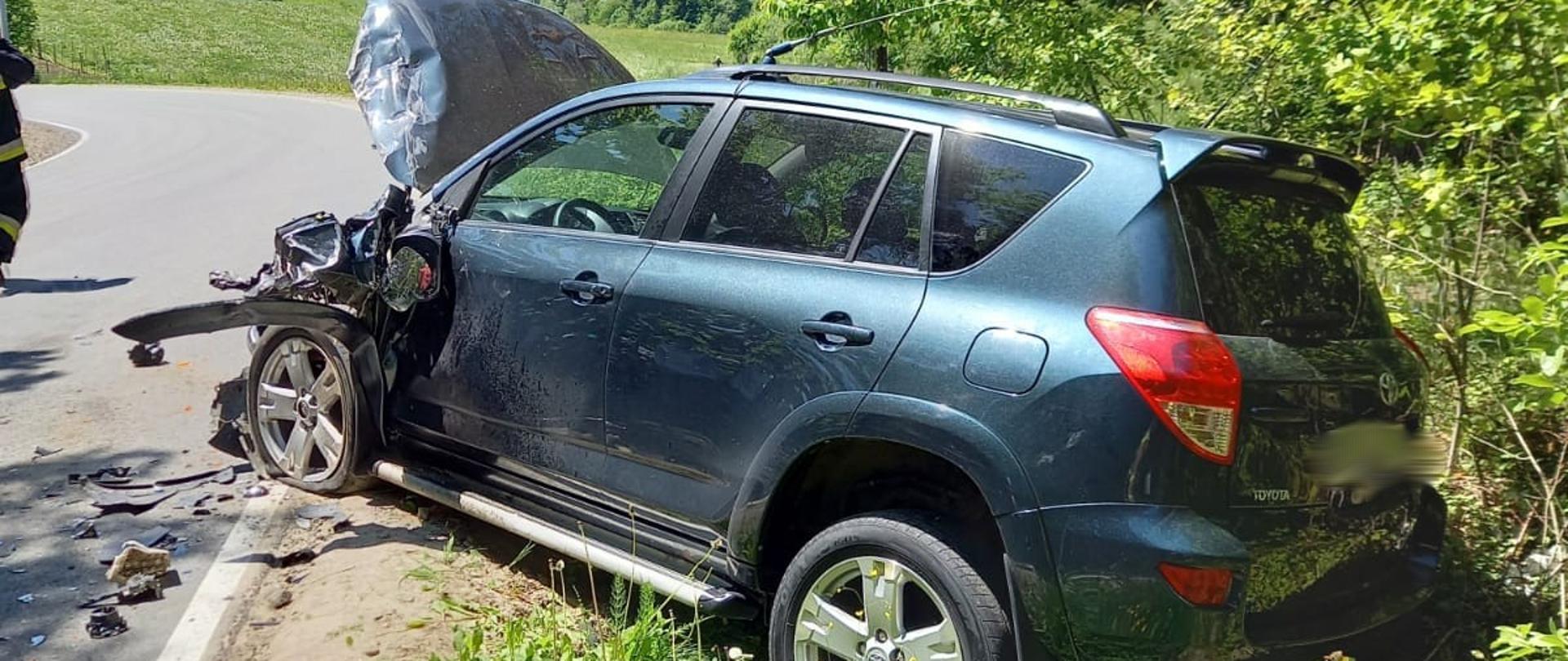 Samochód osobowy w rowie z uszkodzonym przodem.