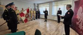 Strażacy i sztandar na świetlicy JRG, strażak składa przysięgę