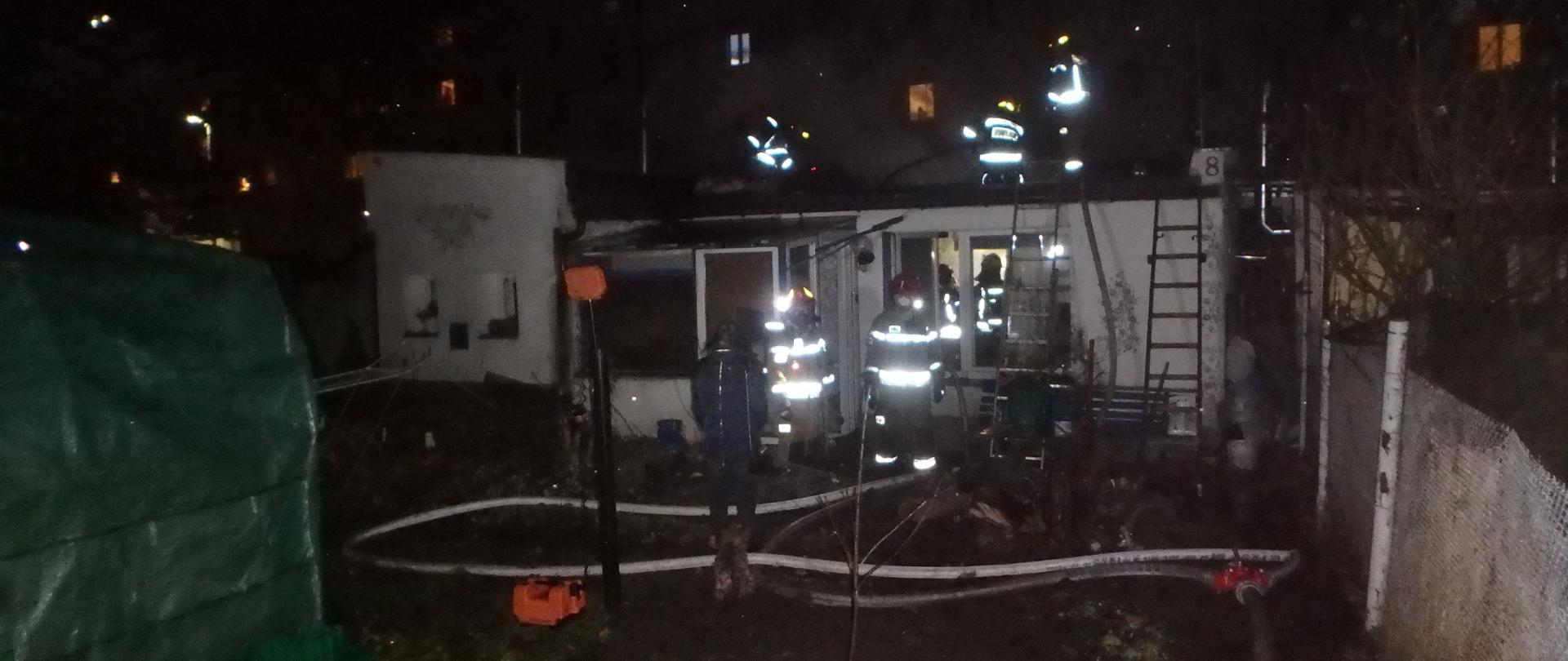 noc, strażacy na dachu budynku 