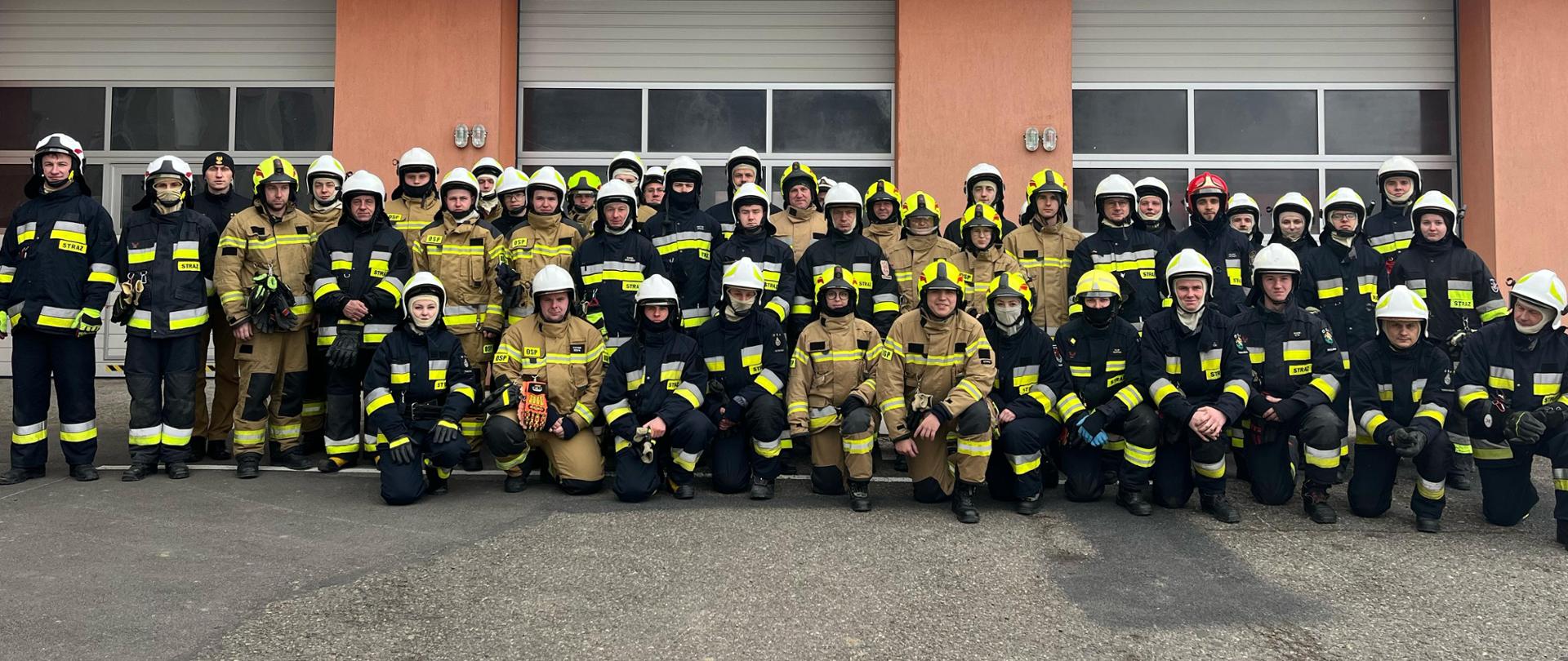 na zdjęciu grupa strażaków – słuchaczy kursu, w tle budynek Komendy