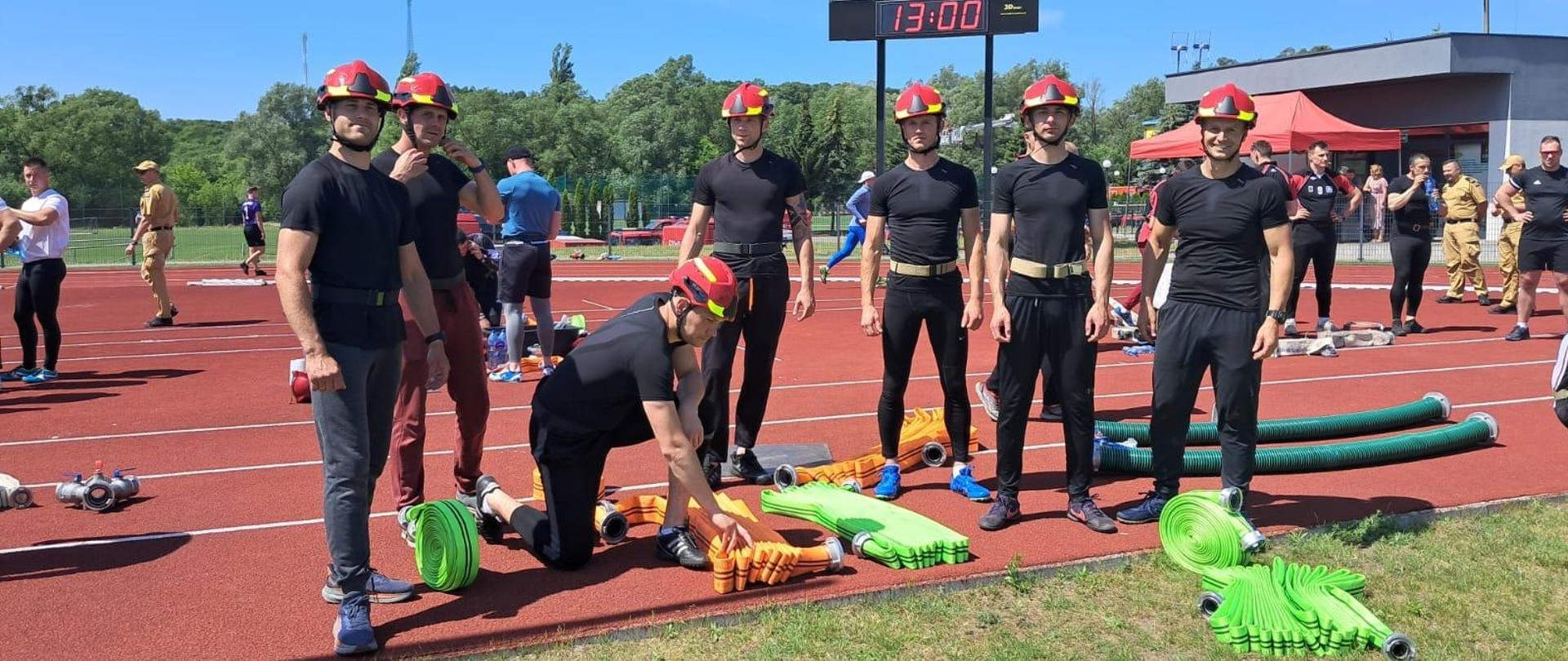 Stadion sportowy. Na zdjęciu drużyna KP PSP Braniewa przed startem w zawodach.
